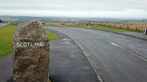 Вид с воздуха на границу между Шотландией и Англией с большим камнем и знаком Шотландии - Великобритания — стоковое видео