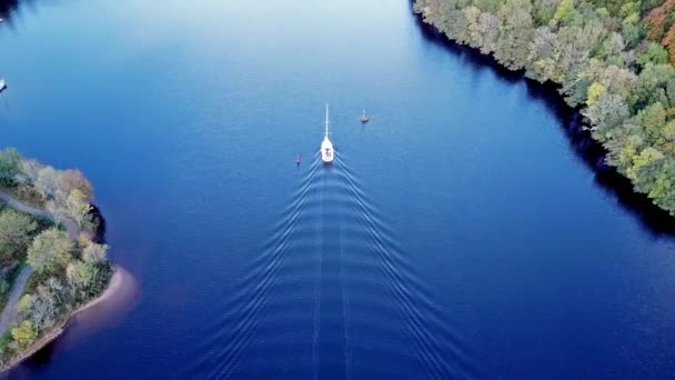 Volando a través del Gran Glen por encima de Loch Oich hacia Loch Ness detrás de un yate de motor blanco en las tierras altas escocesas - Reino Unido — Vídeos de Stock