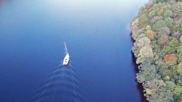 Volando a través del Gran Glen por encima de Loch Oich hacia Loch Ness detrás de un yate de motor blanco en las tierras altas escocesas - Reino Unido — Vídeos de Stock