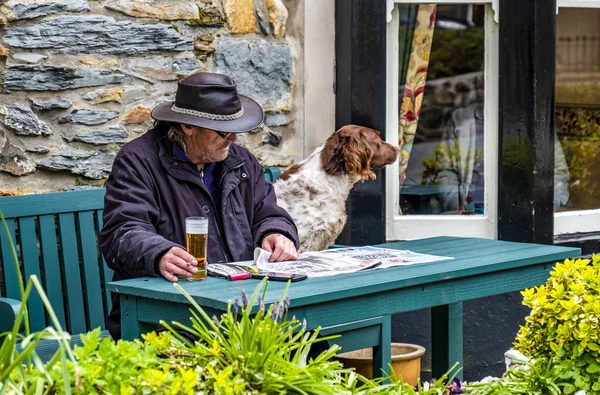 Beddgelert, wales - 3. Mai 2018: Mann und Hund genießen die traditionelle Stadt — Stockfoto