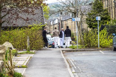 Todmorden , England - May 04 2018 : Refugees walking in the centre of Todmorden which meaning is death killing or slaughtering in German clipart