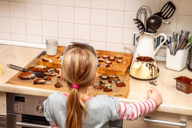 Küçük kız mutfakta ayakta kurabiye hazırlama