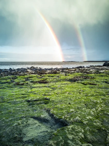 Regenboog boven het beroemde dinosaurus voetafdrukken op een Corran strand door Staffin op het isle of Skye — Stockfoto