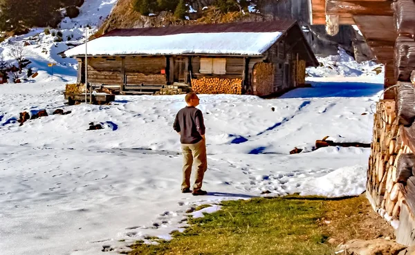 Man genieten van de sneeuw op een alm in Zwitserland — Stockfoto