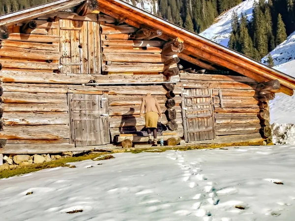 Wanita musim dingin fashion ejpying rumah kayu di salju alpen — Stok Foto