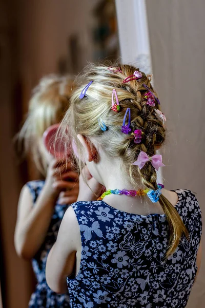 Mała dziewczynka, patrząc w lustro w domu na sobie spódnicę i naszyjnik — Zdjęcie stockowe