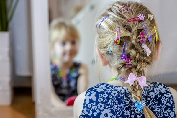 Ragazzina che si guarda allo specchio a casa indossando una gonna e una collana — Foto Stock