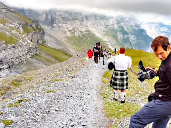 Interlaken, Szwajcaria - wrzesień 2008 09: Davi Kanyari przechodzi w najwyższym punkcie Jungfrau Marathon, w którym gra bagpiper kryje się między północną ścianę szczytu Eiger oraz wzgórza morenowe — Zdjęcie stockowe