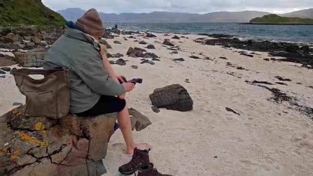 Dame zieht Wanderstiefel am weißen Strand an — Stockvideo