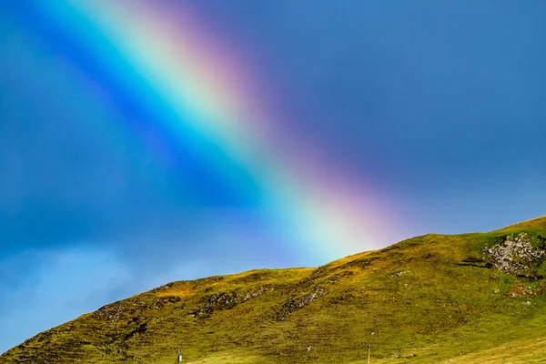 Close-up van de mooie natuurlijke regenboog boven een heuvel — Stockfoto