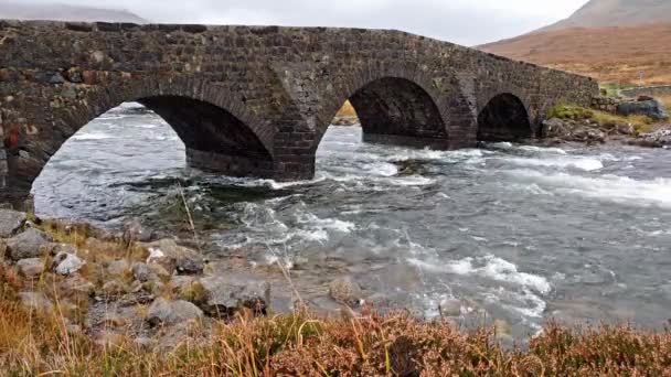 O velho Sligachan pedra ponte sobre o rio Sligachan com montanhas de pico de Cuillin vermelho Beinn Dearg Mhor e Marsco no Outono de Isle of Skye Scotland Uk — Vídeo de Stock