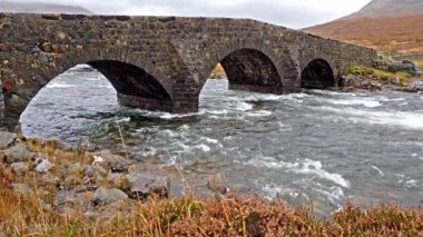 Sligachan eski köprü nehir Sligachan üzerinde Beinn Dearg Mhor ve Marsco kırmızı Cuillin en yüksek dağları ile sonbahar Isle of Skye İskoçya İngiltere taş