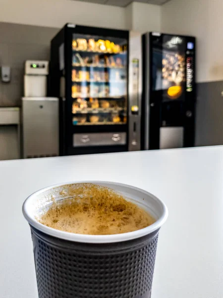 Plastic coffee cup of vending machine standing on table