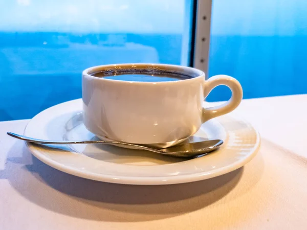 Kopje koffie op een tabel whith de Oceaan in de achtergrond terwijl het cruise-schip is rijden — Stockfoto