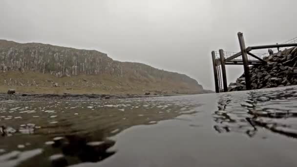 Opname boven en onder het wateroppervlak naast pier — Stockvideo