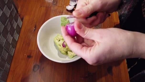 Szeletelés hagyma a guacamole-on iskolapad-ban otthoni konyha — Stock videók