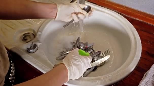 Mulher lavando talheres na cozinha com luvas — Vídeo de Stock