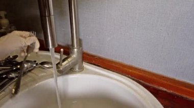 Kadın çamaşır çatal eldiven ile mutfakta