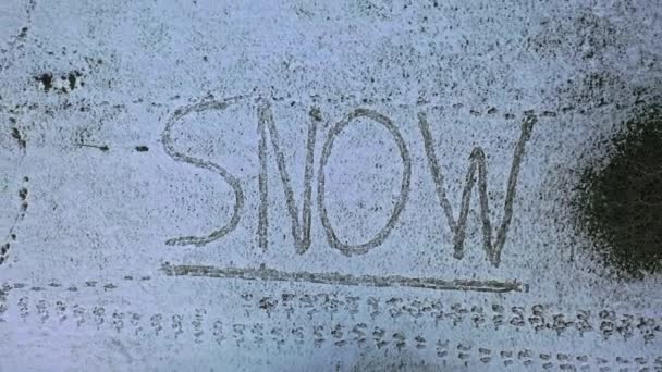 Fliegen über dem in Schnee geschriebenen Wort Schnee — Stockvideo