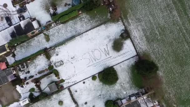 Volando por encima de la palabra nieve escrita en la nieve — Vídeos de Stock