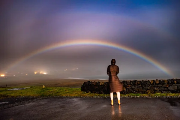 Леді спостереження дуже рідкісних moonbow протягом ночі вище місті Staffin Бей - острів Скай, Шотландія — стокове фото