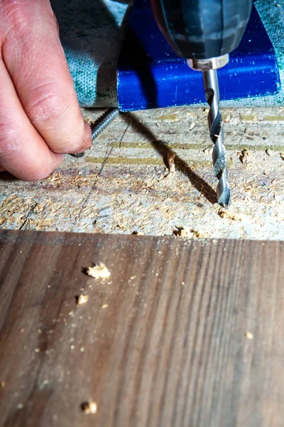 Мужчина пользуется дрилл-машиной, устанавливая дома новое деревянное ламинатное покрытие . — стоковое фото