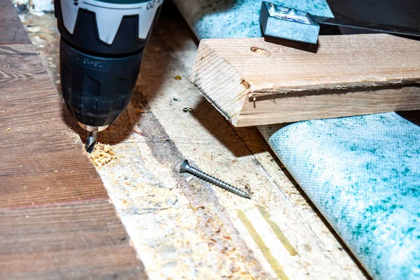 남자 집에서 바닥 새로운 나무 합판을 설치 하는 동안 드릴 기계를 사용 하 여. — 스톡 사진