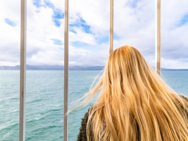 Parmaklıkların arasından arıyorum ve deniz ve kara arıyorum sarışın Bayan