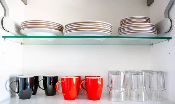 Kitchen cupboard with disheslike plates, cups and glasses — Stock Photo, Image