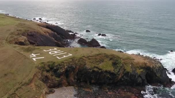 Volando sobre la costa de la ruta costera del Atlántico por Maghery con el signo Eire 74, Dungloe - Condado de Donegal - Irlanda — Vídeo de stock