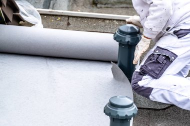 Katranlı muşamba yere korumak için sayfayı kapsayan olarak kullanarak inşaat işçisi