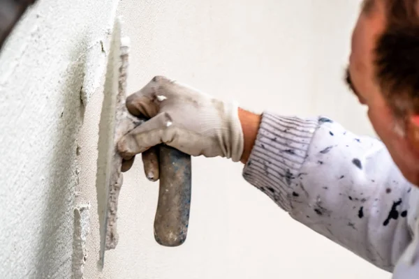 Travailleur de la construction plâtrage et lissage mur de béton avec du ciment — Photo