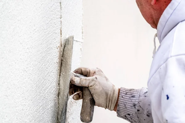 Шпаклевка и сглаживание бетонных стен строительными рабочими — стоковое фото