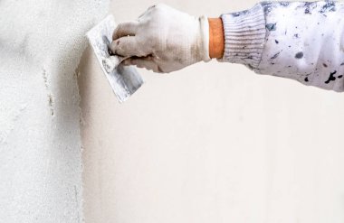 Construction worker plastering and smoothing concrete wall with cement clipart
