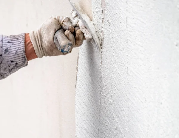 Bouwvakker stukadoors en vloeiend maken van betonnen wand met cement — Stockfoto