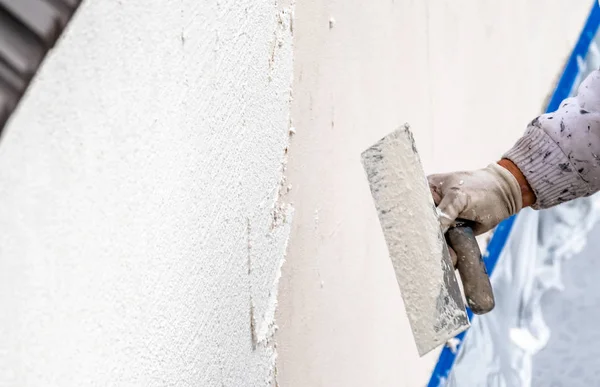 Travailleur de la construction plâtrage et lissage mur de béton avec du ciment — Photo