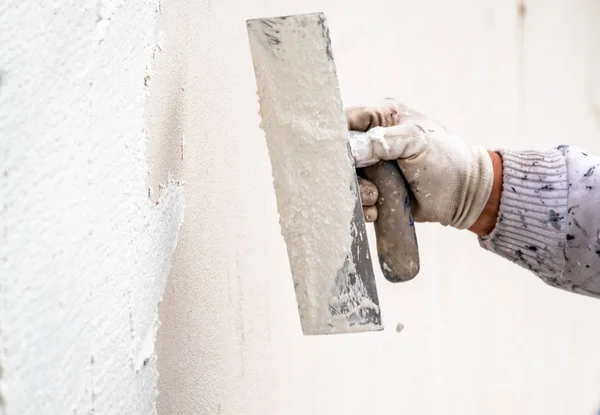 Stavební dělník-omítky a vyhlazování betonové zdi s cementem — Stock fotografie