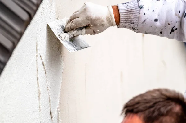 Trabalhador da construção civil reboco e alisamento parede de concreto com cimento — Fotografia de Stock