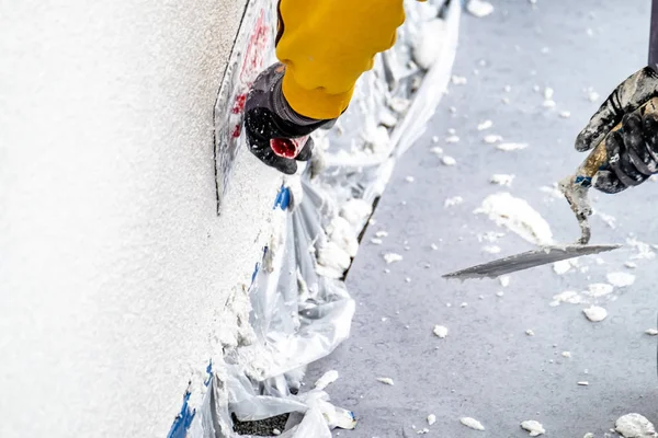 Byggnadsarbetare rappning och utjämning betongvägg med cement — Stockfoto