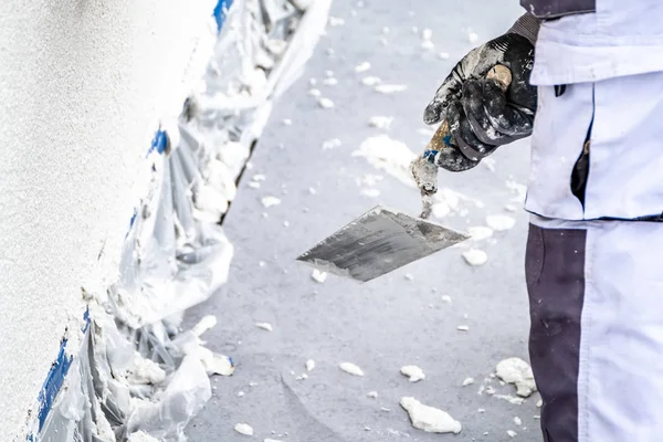 Byggnadsarbetare rappning och utjämning betongvägg med cement — Stockfoto