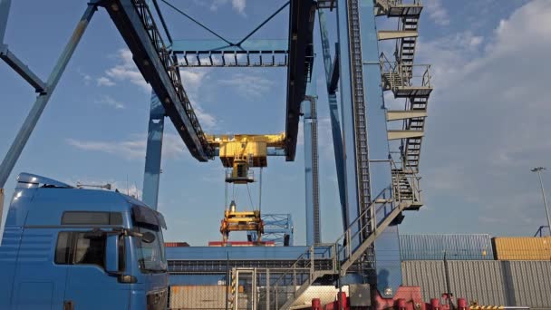 Gantry crane is unloading a container from a ship at daytime in the port of Duisburg - Germany. — Stock Video