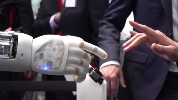 Человеческая рука и роботы как символ связи между людьми и искусственным интеллектом выполняя тяжелый металлический знак — стоковое видео