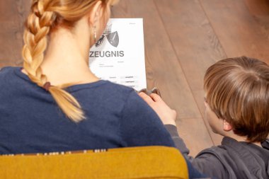 Anne elinde çok kötü bir Alman okul sertifikası tutan çeviri: Doğum disiplinlerinin sertifika günü müzik okuma din Almanca İngilizce matematik sanat matematik yetersiz sınıf f
