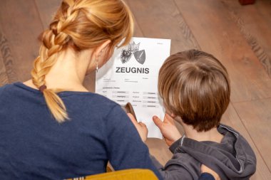 Anne elinde çok kötü bir Alman okul sertifikası tutan çeviri: Doğum disiplinlerinin sertifika günü müzik okuma din Almanca İngilizce matematik sanat matematik yetersiz sınıf f