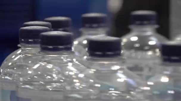 Produzione di acqua potabile in bottiglie di plastica che si muovono su nastro trasportatore — Video Stock