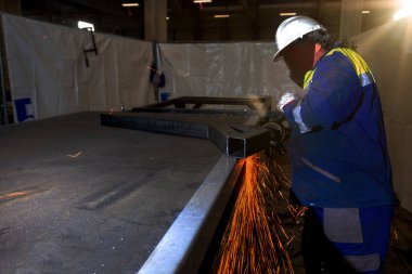 İnşaat alanında açı öğütücü kullanan işçiler