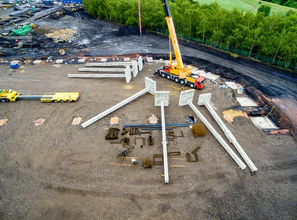 Aerial view of huge crane installing huge reinforced concrete piles on construction site — Stock Image Aerial view of huge crane installing huge reinforced concrete piles on construction site Royalty Free Stock Photos