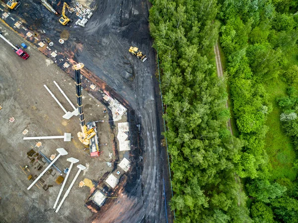 Aerial view of huge crane installing huge reinforced concrete piles on construction site — Stock Image Aerial view of huge crane installing huge reinforced concrete piles on construction site Stock Picture