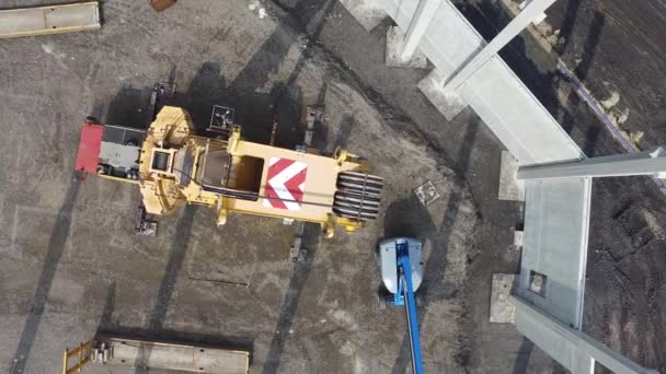 Luftaufnahme eines riesigen Krans, der riesige Stahlbetonpfähle auf der Baustelle installiert — Stockvideo
