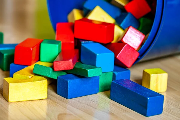 Colorful wooden building blocks on floor . Selective focus